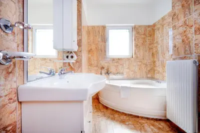 a white bathroom with a tub and a sink at Wonderful Villa in Chania with Private Pool, Panoramic Sea Views & Spacious Interiors in Agios Onoufrios