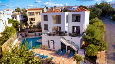 an aerial view of a white house with a swimming pool at Wonderful Villa in Chania with Private Pool, Panoramic Sea Views & Spacious Interiors in Agios Onoufrios