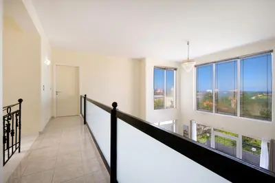 a staircase in a house with large windows at Wonderful Villa in Chania with Private Pool, Panoramic Sea Views & Spacious Interiors in Agios Onoufrios