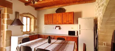 a kitchen with a white refrigerator and wooden cabinets at Irene's Guest House in Frés