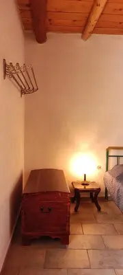 a room with a table and a bed and a lamp at Irene's Guest House in Frés