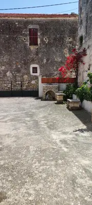 a stone building with a window and a fence at Irene's Guest House in Frés