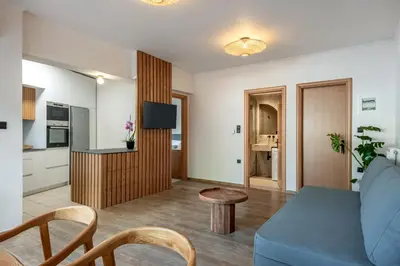a living room with a blue couch and a kitchen at Soleado Studio in Chania Town