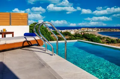 a swimming pool with a view of the ocean at Amphitheatre Suites in Palaiochóra