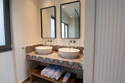 two sinks in a bathroom with two mirrors at Amphitheatre Suites in Palaiochóra