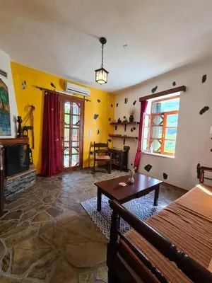 a living room with a table and a fireplace at Spitia Katoi in Palaiochóra