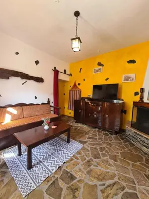 a living room with a couch and a tv at Spitia Katoi in Palaiochóra