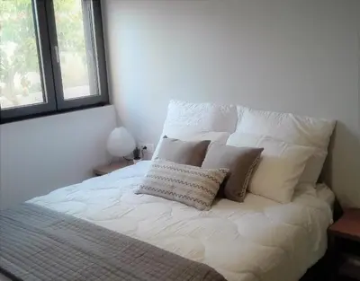 a white bed with pillows on it in a bedroom at New Sea Escape Boutique Apt-Agii Aposto li beach in Chania Town