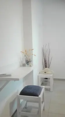 a white room with a bench and a white table at New Sea Escape Boutique Apt-Agii Aposto li beach in Chania Town