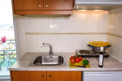 a kitchen counter with a sink and fruits and vegetables at Room 25 in Chania Town