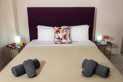 a bedroom with a bed with two pillows on it at Room 25 in Chania Town