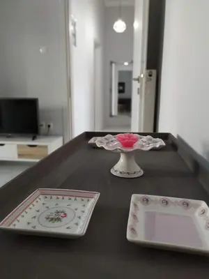 a table with two plates and a vase on it at Sunday Apartment Chania 2B in Chania Town