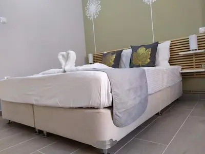 a large bed with white sheets and pillows at Sunday Apartment Chania 2B in Chania Town