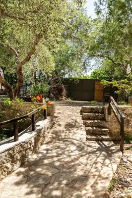a path in a park with trees and a fence at Villa Aloni in Fílippos