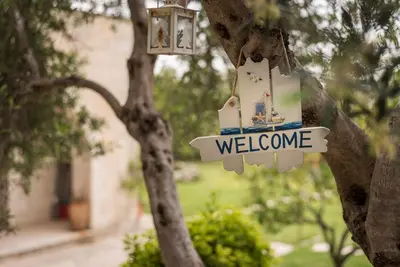 a sign that says welcome hanging from a tree at Villa Aloni in Fílippos
