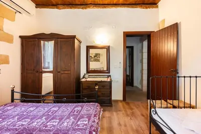 a bedroom with a bed and a dresser and a mirror at Villa Aloni in Fílippos