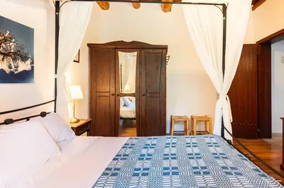 a bedroom with a bed with a blue and white bedspread at Villa Aloni in Fílippos