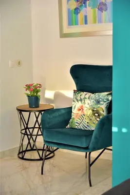 a green chair and a table with a pillow on it at Emerald Apartment Halepa in Chania Town