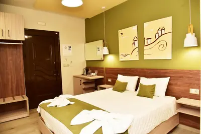 a hotel room with a bed with white sheets at Lafo Rooms in Elafonisi