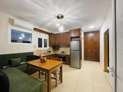 a living room with a table and a kitchen at Lafo Rooms in Elafonisi