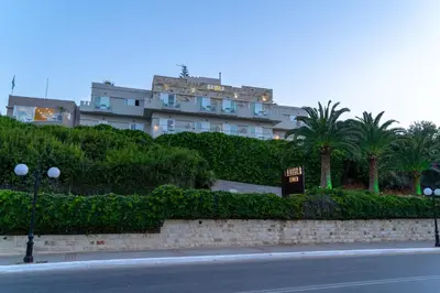 a building with a sign in front of a street at Abella Hotel in Agia Marina Nea Kydonias