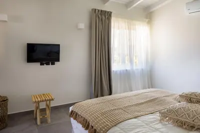a bedroom with a bed and a television on the wall at s u e ñ o - studios and apartments, with shared pool in Kato Daratso