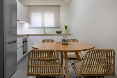 a kitchen with a wooden table and two chairs at s u e ñ o - studios and apartments, with shared pool in Kato Daratso