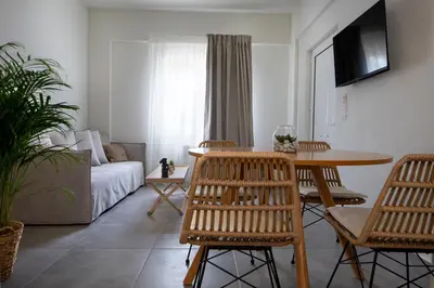 a living room with a table and chairs and a couch at s u e ñ o - studios and apartments, with shared pool in Kato Daratso