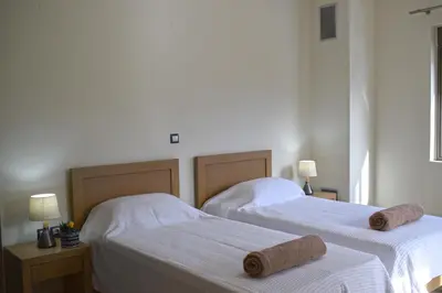 two beds in a bedroom with towels on them at Four Seasons Homes in Stalos