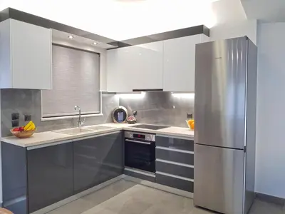 a kitchen with white cabinets and a stainless steel refrigerator at Four Seasons Homes in Stalos