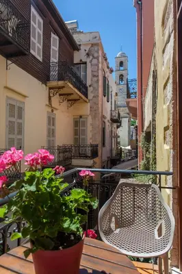 a balcony with a table and a chair and flowers at Charming Studio in the Old Town in Chania Town