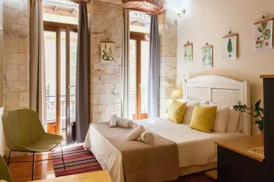 a bedroom with a bed with yellow pillows and a chair at Charming Studio in the Old Town in Chania Town