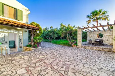 a stone driveway in front of a house at Venizelos Studios in Plataniás