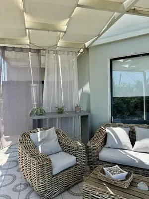 a room with wicker chairs and a bed and a table at Venizelos Studios in Plataniás