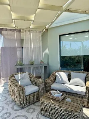a living room with two wicker chairs and a table at Venizelos Studios in Plataniás