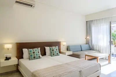 a bedroom with a large bed and a couch at Despina Apartments in Plataniás