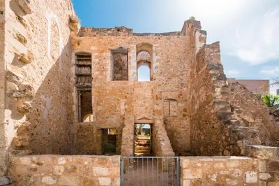 an old brick building with a gate in front at Casa Dei Miracoli in Chania Town