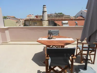 a wooden table and chairs on a roof at Casa Dasyra in Chania Town
