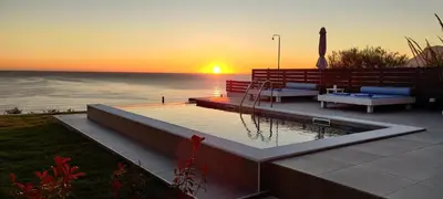 a sunset over the ocean with a pool and bench at Blue Green Villa Kalyves eco pool premium quality in Kalyves