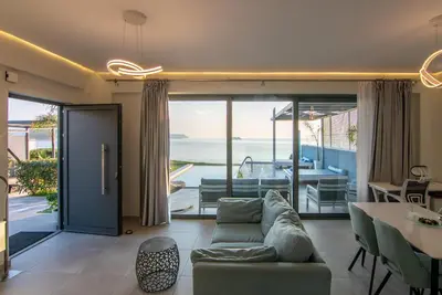 a living room with a couch and a view of the ocean at Blue Green Villa Kalyves eco pool premium quality in Kalyves