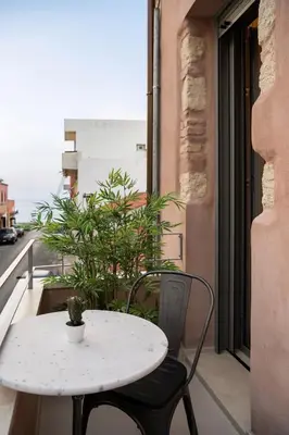 a white table and two chairs on a balcony with a table at Chania Escapes City Loft 50 meters by the Sea in Chania Town