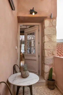 a table and chairs in front of a door at Chania Escapes City Loft 50 meters by the Sea in Chania Town
