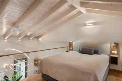 a bedroom with a large bed in a attic at Chania Escapes City Loft 50 meters by the Sea in Chania Town