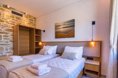 two beds in a hotel room with towels on them at Athinais villa in Palaiochóra