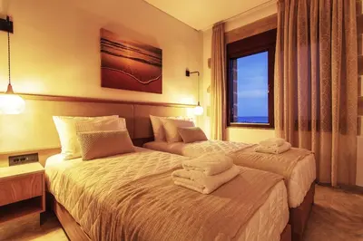 two beds in a hotel room with towels on them at Athinais villa in Palaiochóra