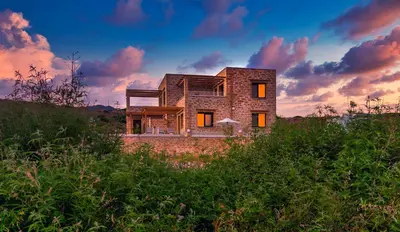 a brick house sitting on top of a hill at Athinais villa in Palaiochóra