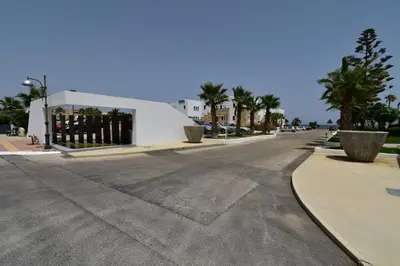 an empty street with palm trees and a building at Geraniotis Hotel and Resort in Plataniás