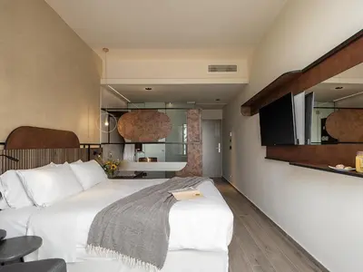 a bedroom with a large white bed in a room at Geraniotis Hotel and Resort in Plataniás