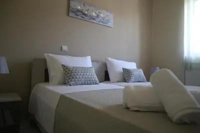a bedroom with two beds with white sheets and pillows at Kleanthi's House in Chania Town