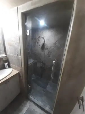 a shower with a glass door in a bathroom at Utsi in Liyidhés
